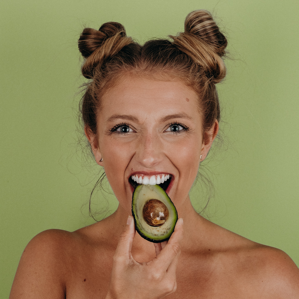 Girl eating an avocado