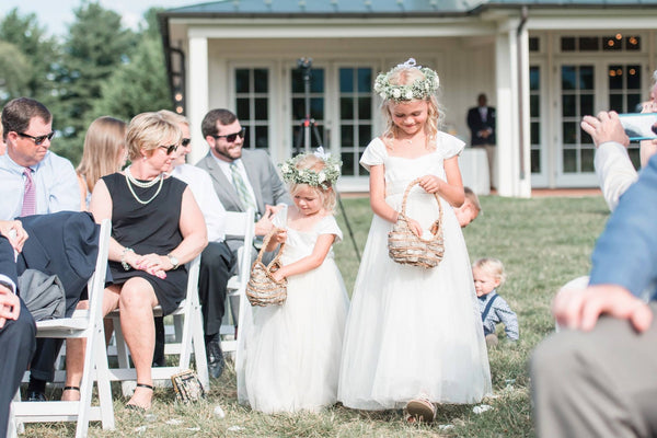 Flower girls walking down the aisle in ivory classic style dresses Ana Balahan