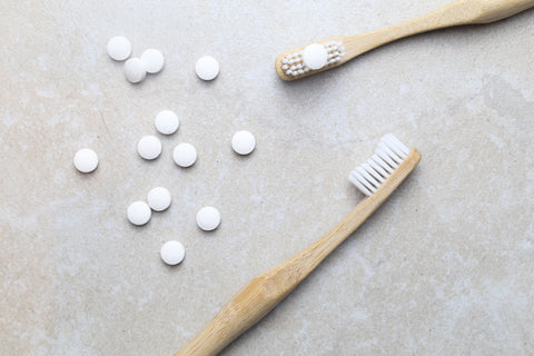 toothpaste tablets made in uk fluoride free being show on a bamboo toothbrush