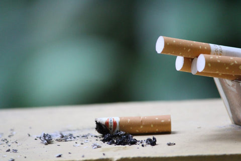a cigarette butt on top of a table with 3 other ciragettes close by