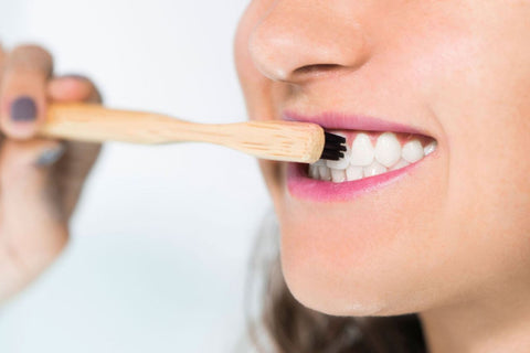 Dupont bristles being shown as a girl brushing her teeth with a bamboo toothbrush - Benefits and Sustainability