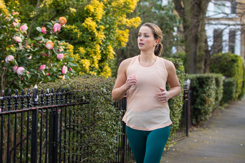 Lady keeping fit and going for a jog outside in spring