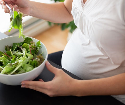 pregnant woman eating greens