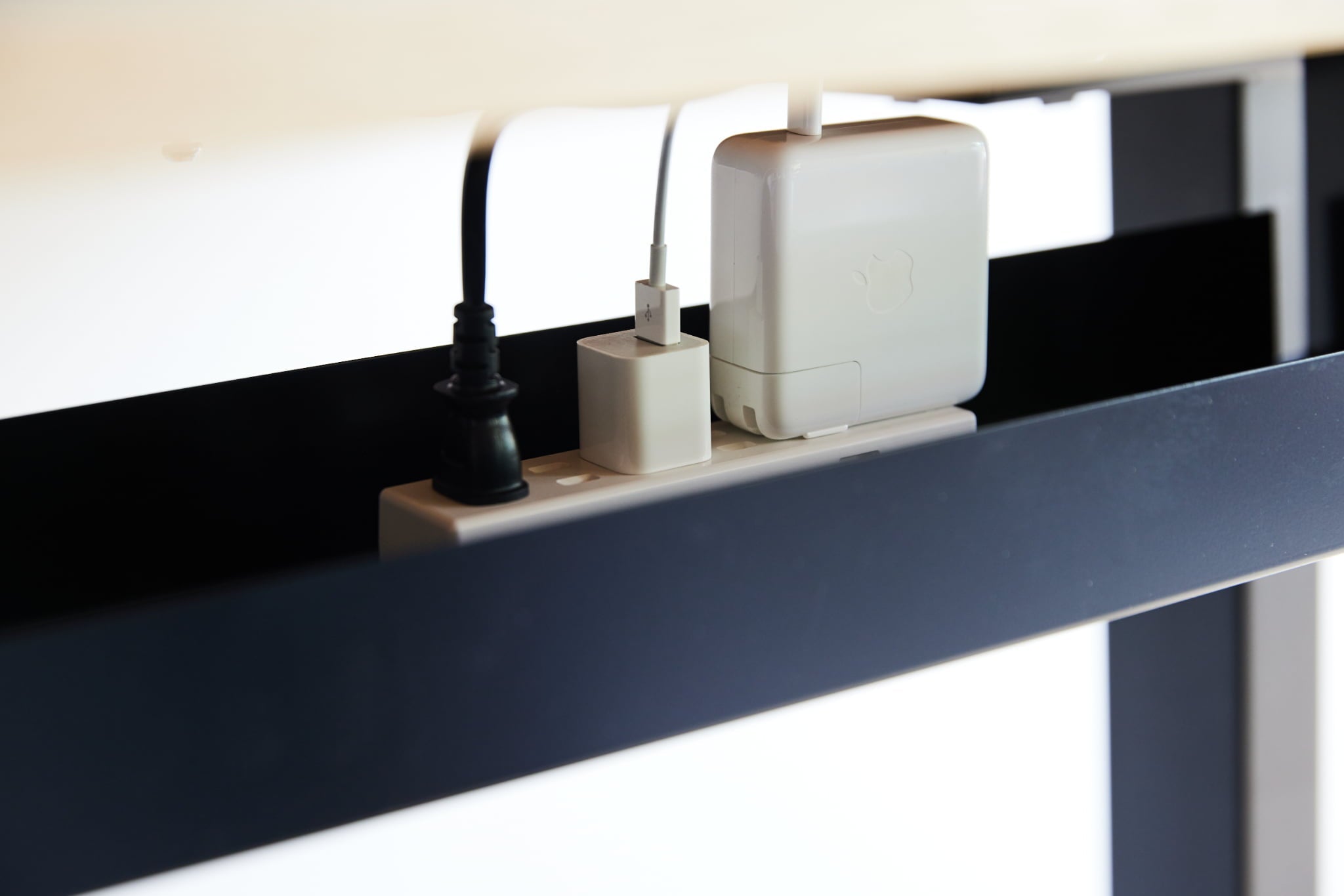 WAAKstanding［無垢材を贅沢に使用した電動昇降デスク］は天板の下に取り付けることで電源タップなどを収納することができる配線トレーを取り付けることで配線を美しく整理することができます。