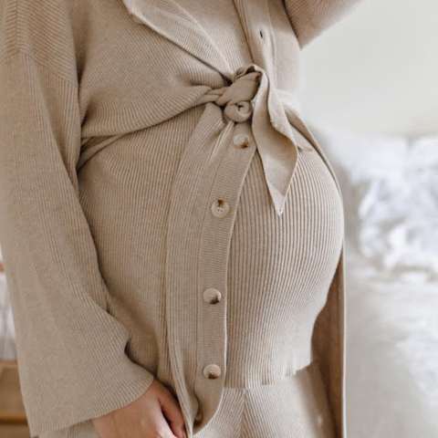 pregnant photographer taking self portrait with her growing belly.