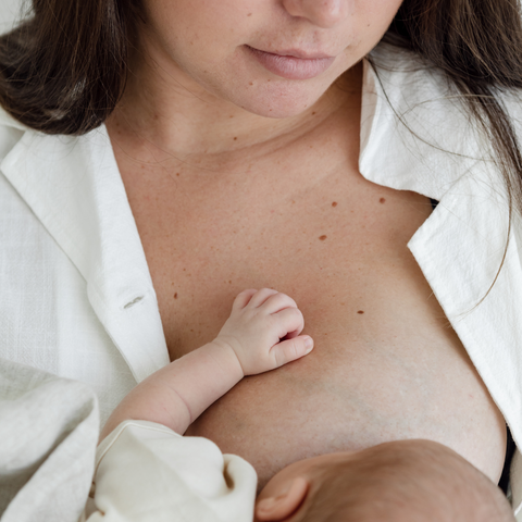 A newborn learning how to breastfeed in the early days of breastfeeding. 