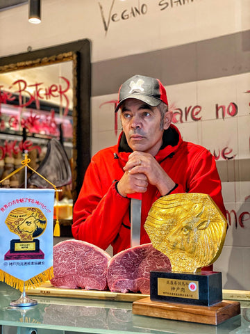 Claudio Callegari vicino a un tagliere di carne di kobe e il premio di rivenditore ufficiale davanti