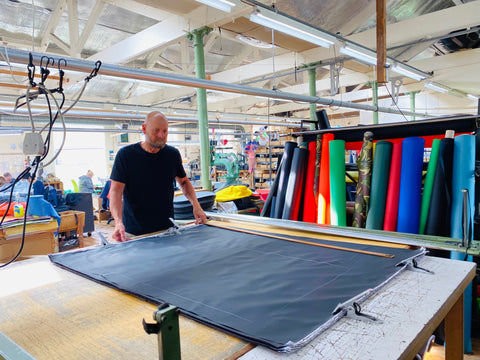 Man in factory cutting out matting for a Turtleback bag