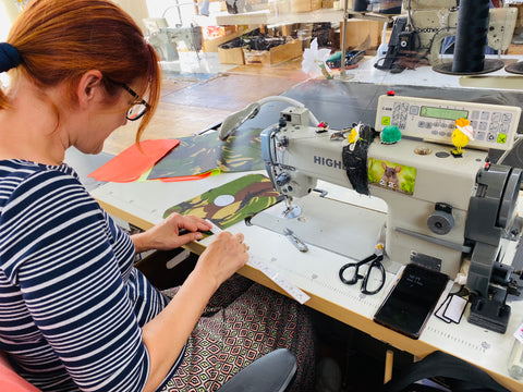 Woman at a sewing machine working on a Swim Feral bag