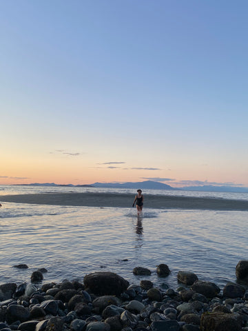 Mercedes out in the water with the sun setting behind her