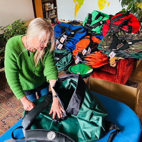 Woman packing up Swim Feral Turtlback bags ready to send off to customers