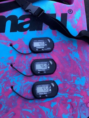 Three thermometers on a wet suit displaying temperatures ranging from 4 to 4.9 degrees centigrade.  