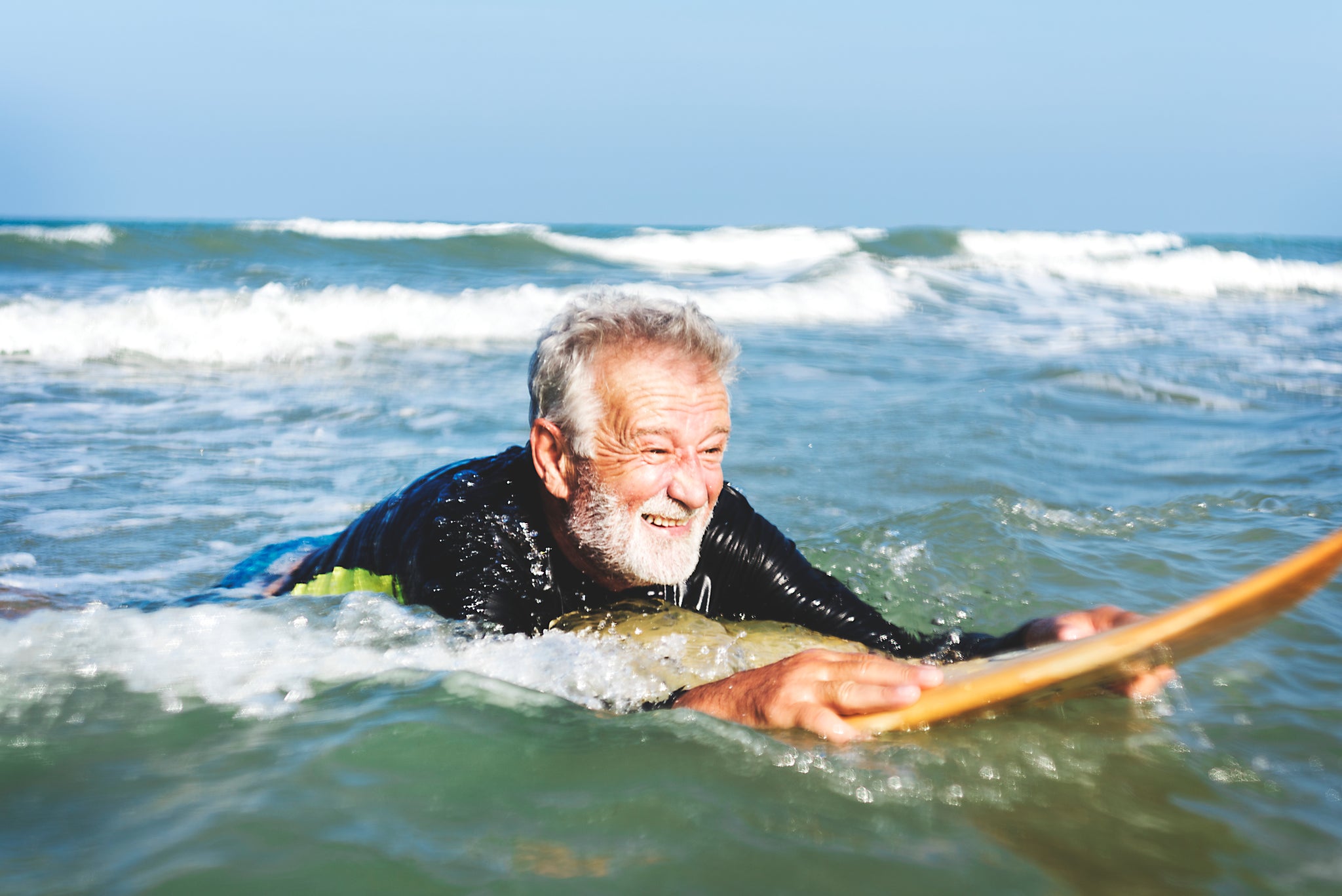 Älterer Mann auf einem Surfboard
