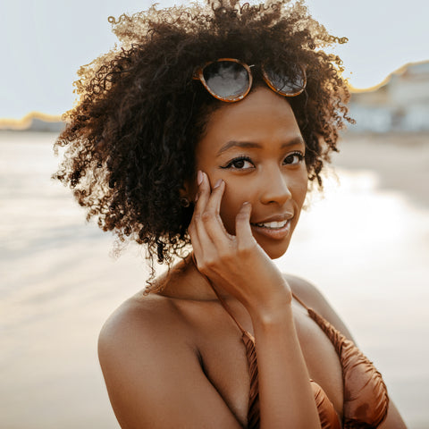 A curly-haired woman at the beach.