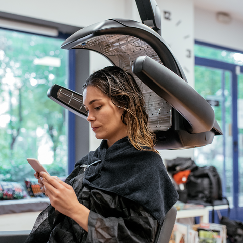 A woman getting her hair dried at a salon.