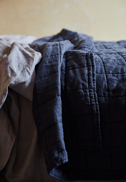 Blue linen sheet set on sand linen quilt sideways