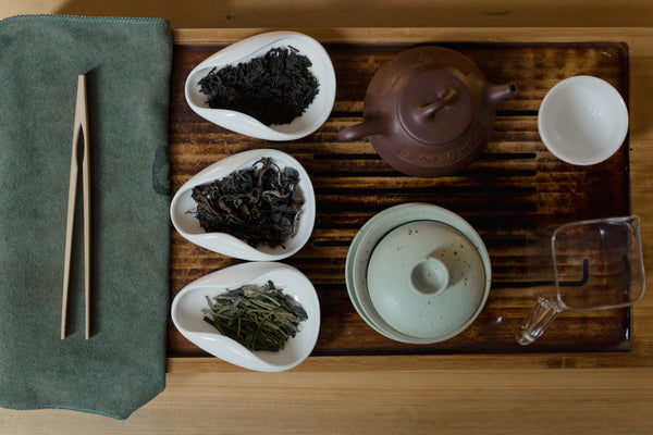 A selection of three teas and teapot on a tray