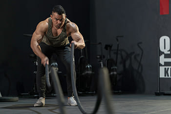 Mann beim Battle Rope Training
