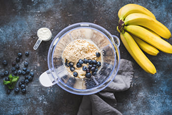 Mixer mit Blaubeeren, Haferflocken, Bananen