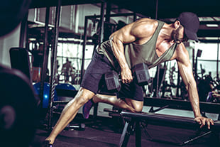 Mann macht Kurzhantel Rudern im Gym