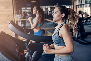 Frau joggt auf Laufband