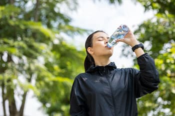 Frau trinkt Wasser aus einer Flasche