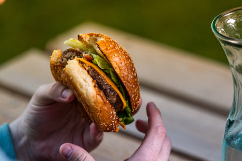 someone taking a bite of a Wagyu beef burger