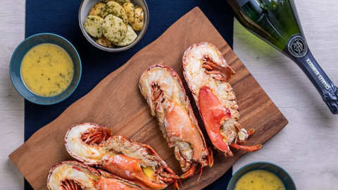 lobster, butter sauce and champagne on a dining table