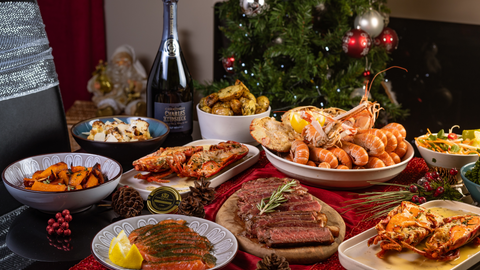 a dining table filled with seafood and steak from a Christmas delivery box