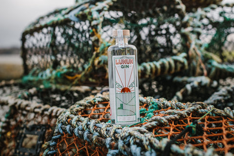 bottle of Lunun gin propped on some fishing nets