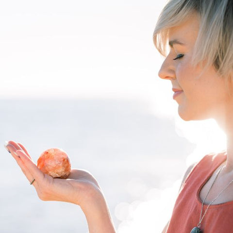 Woman Holding a Red Hematoid Quartz Sphere - How to Pick Out Crystals