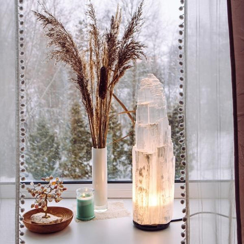 A selenite lamp glowing on the window sill - how to use crystals in the home