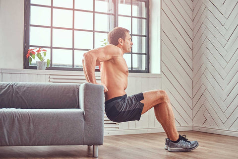 man doing dips in living room