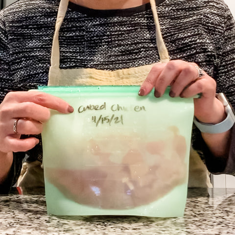 Woman holding labeled green silicone bag