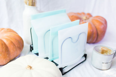 Drying rack drying reusable blue and white silicone bags in a fall setting