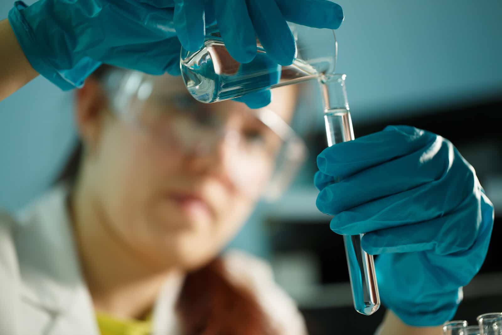 lab assistant pouring liquid into test tube