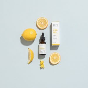 Joy Organics Summer Lemon CBD Oil surrounded by lemons