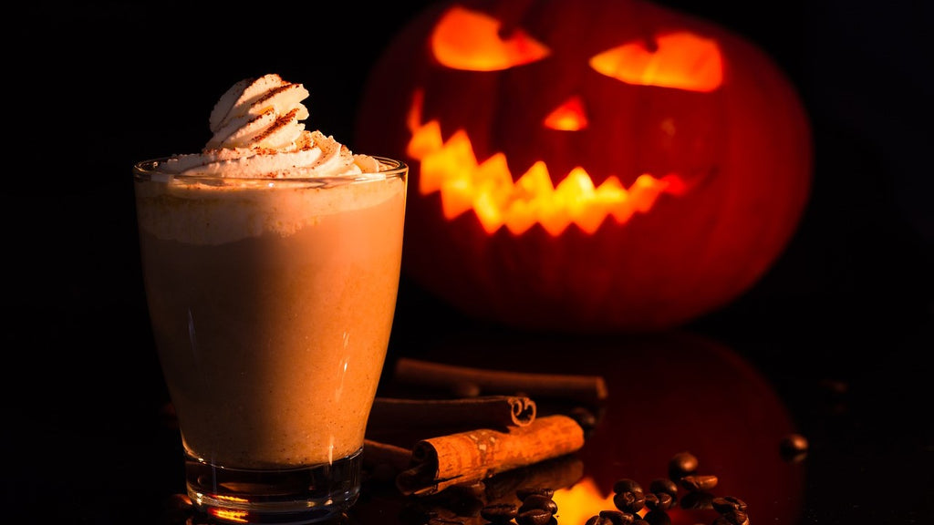 Pumpkin Spice Latte vor beleuchtetem Kürbis