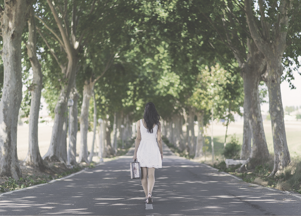 woman-walking-away-down-empty-tree-lined-street