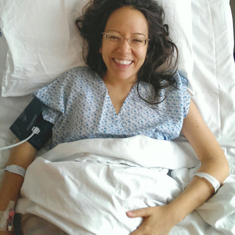 Lar in a hospital bed smiling