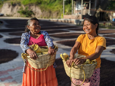 San Lazaro Coffee farm sisters with baskets of coffee cherries