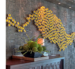 An organic flowing design using Gold Seed Wall Play on a wall with a console table in front of it.