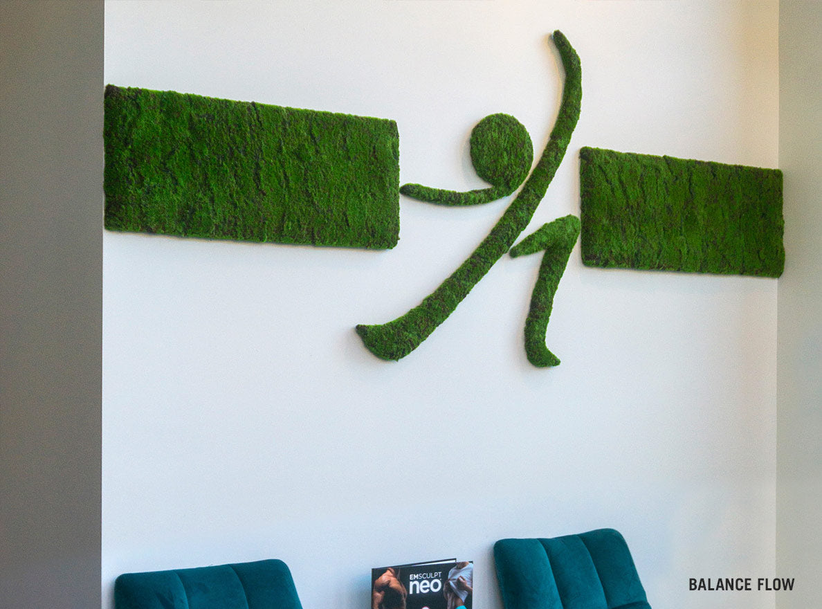 Close up of anthropomorphic moss green wall Logo on a white wall in a yoga studio.