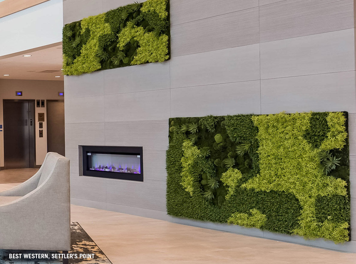 Two large green walls and a fireplace on a stone wall in a hotel lobby.