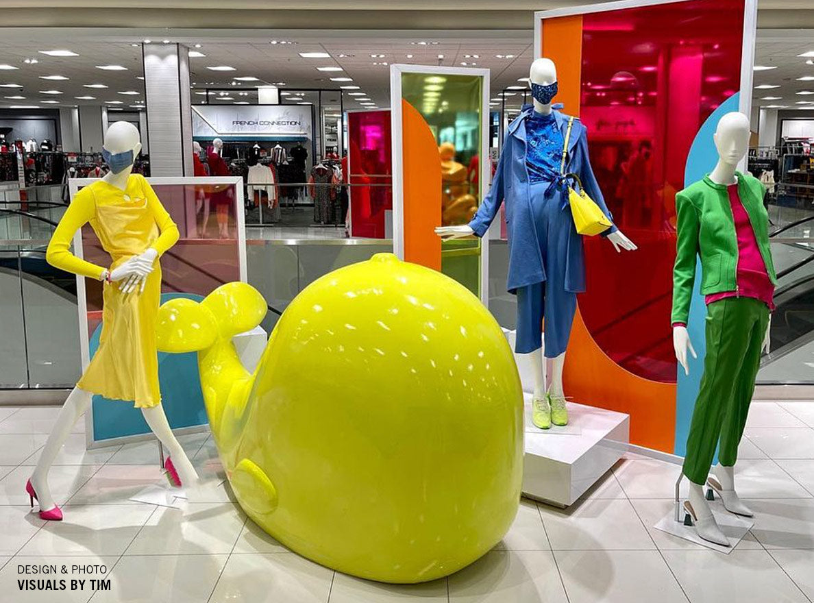 Large yellow whale sculpture in a Macy's fasion display.