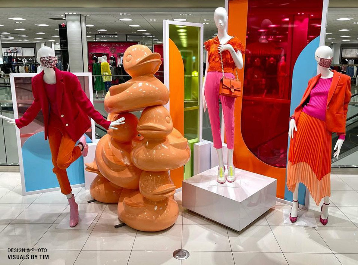 A stack of orange ducks in a Macy's fashion display.