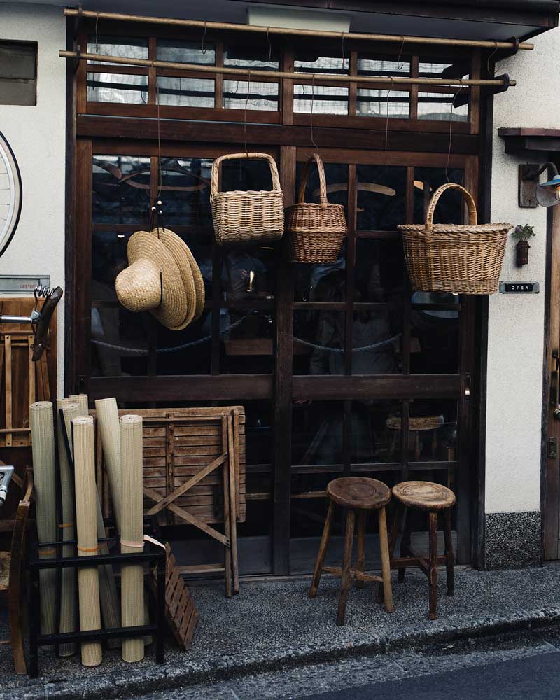 Baskets and wooden stools hanging outside shop front