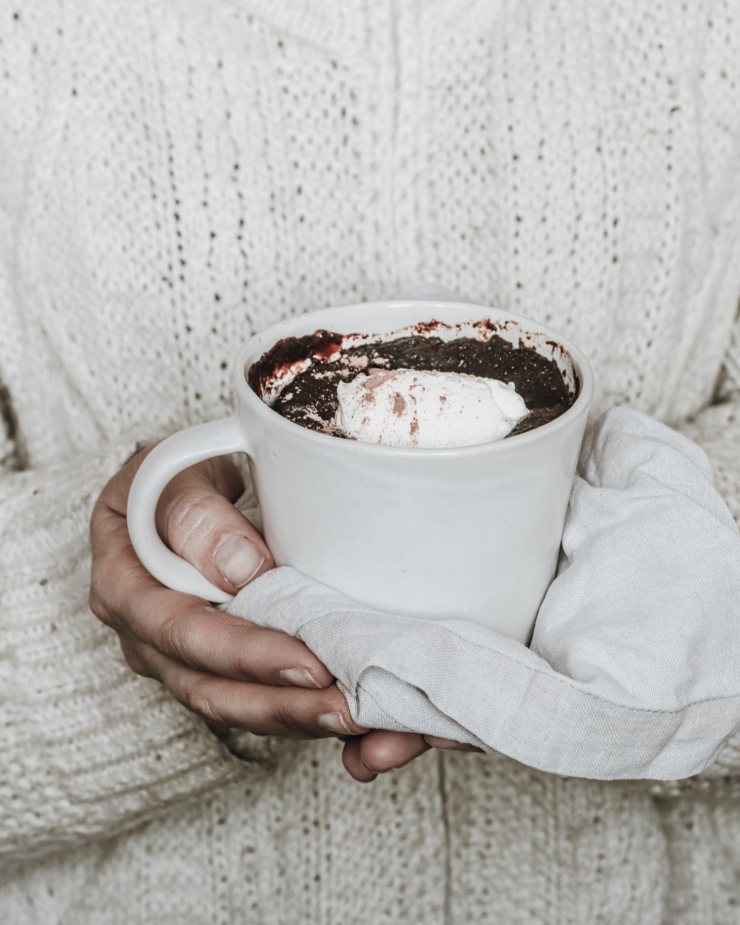 Chocolate pudding being held with tea towel in Stoneware mug