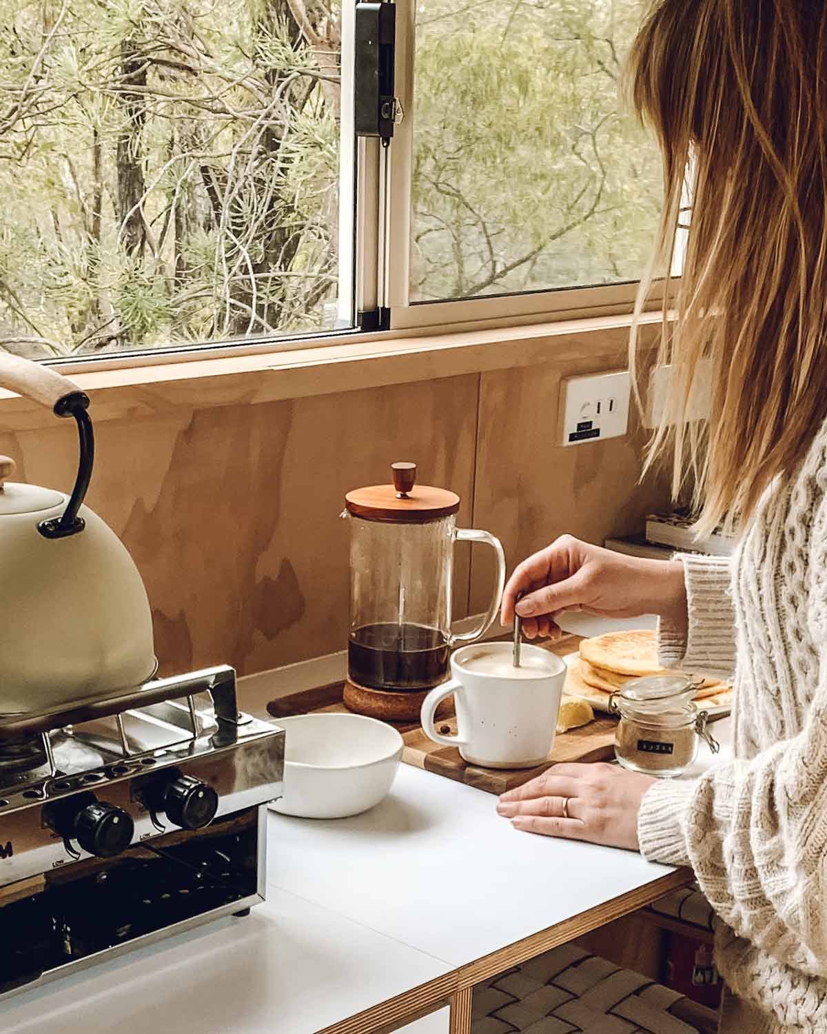 Making a coffee in a tiny cabin, window looking to nature outside