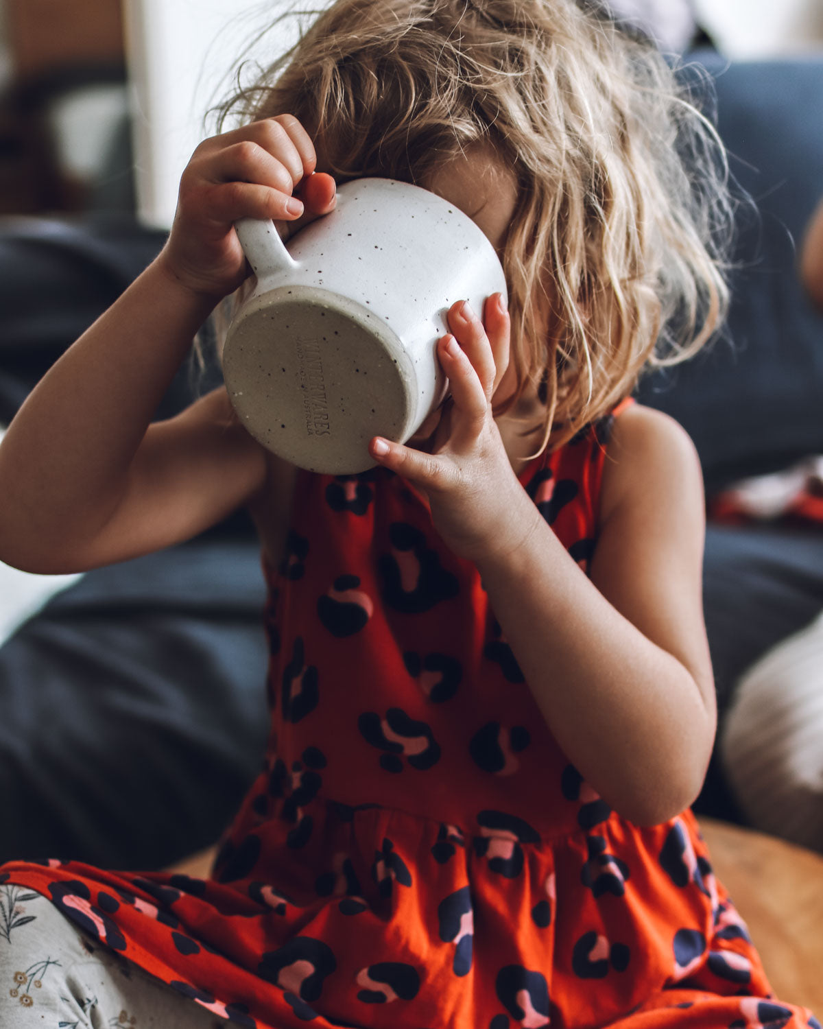 Young girl drinking milk from a handmade mug
